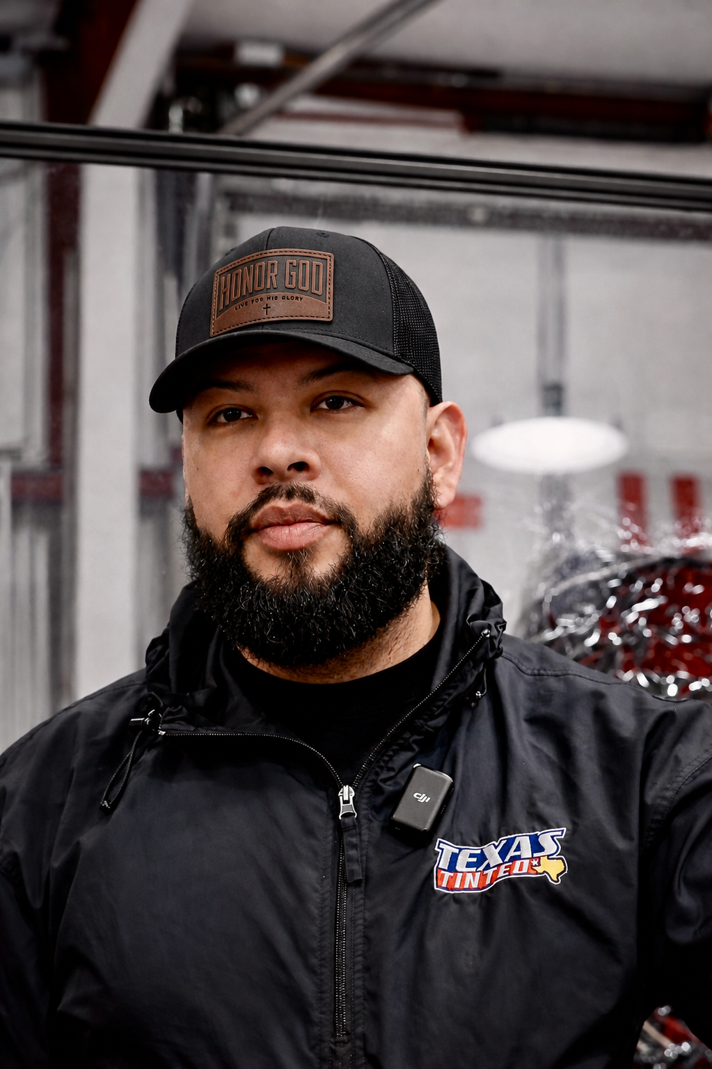 Mauricio Chapa, owner of Texas Tinted, wearing the HONOR GOD cap in his Houston shop